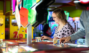 Woman smiling and playing with pushers at namco funscape