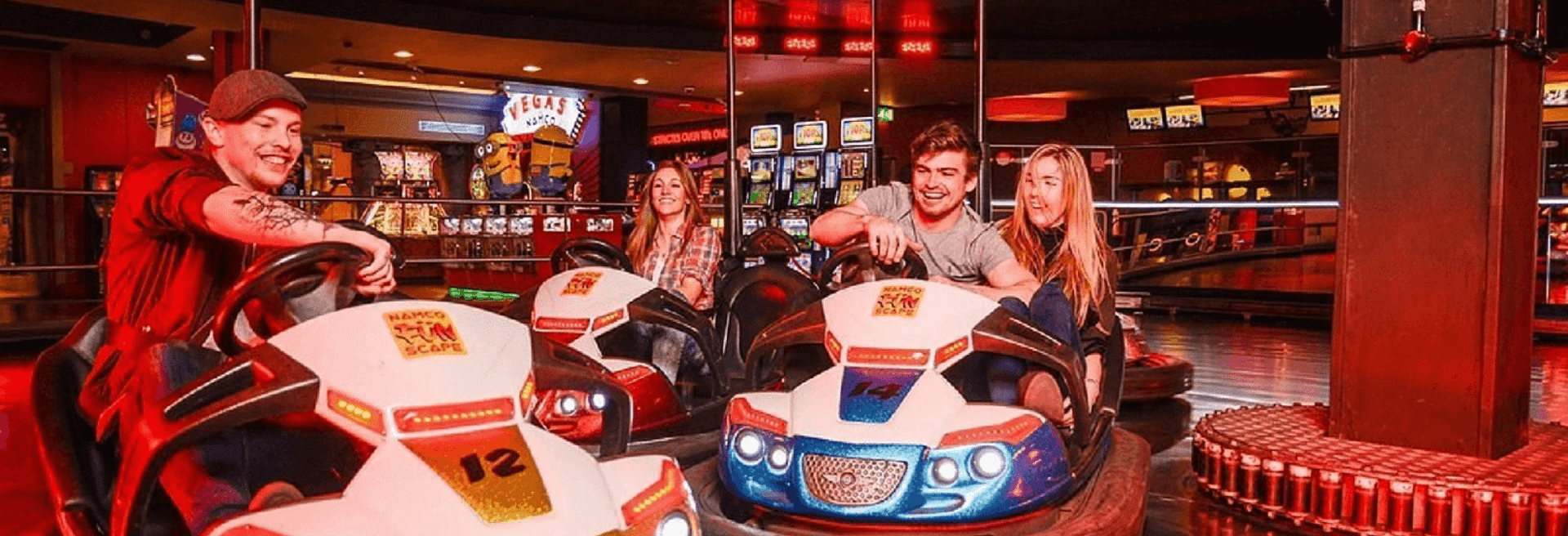 group of friends laughing whilst driving on some indoor dodgems at namco funscape