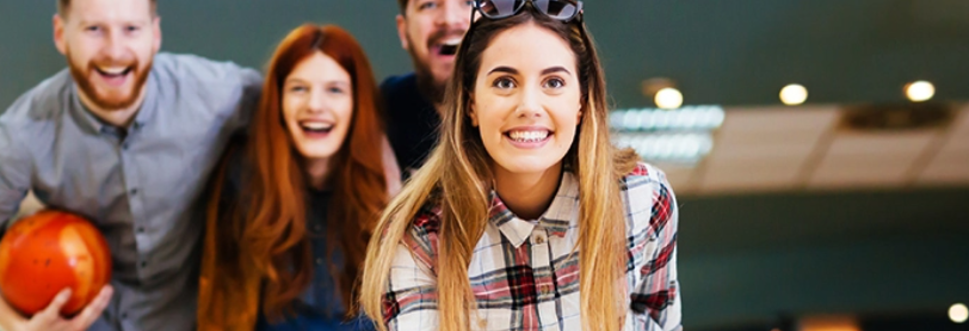 group of friends smiling and having fun whilst bowling 