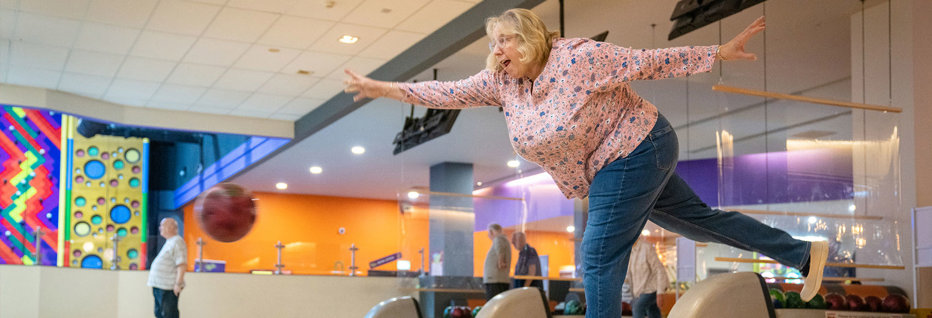 lady smiling and laughing whilst having fun whilst bowling a bowling ball during over fifties bowling 