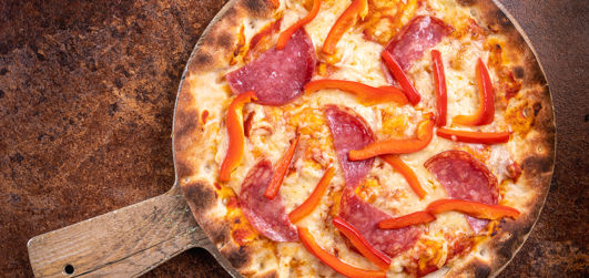 Pepperoni, with Bell peppers, Cheddar, Mozzarella, tomato sauce and rocket served on a pizza plate