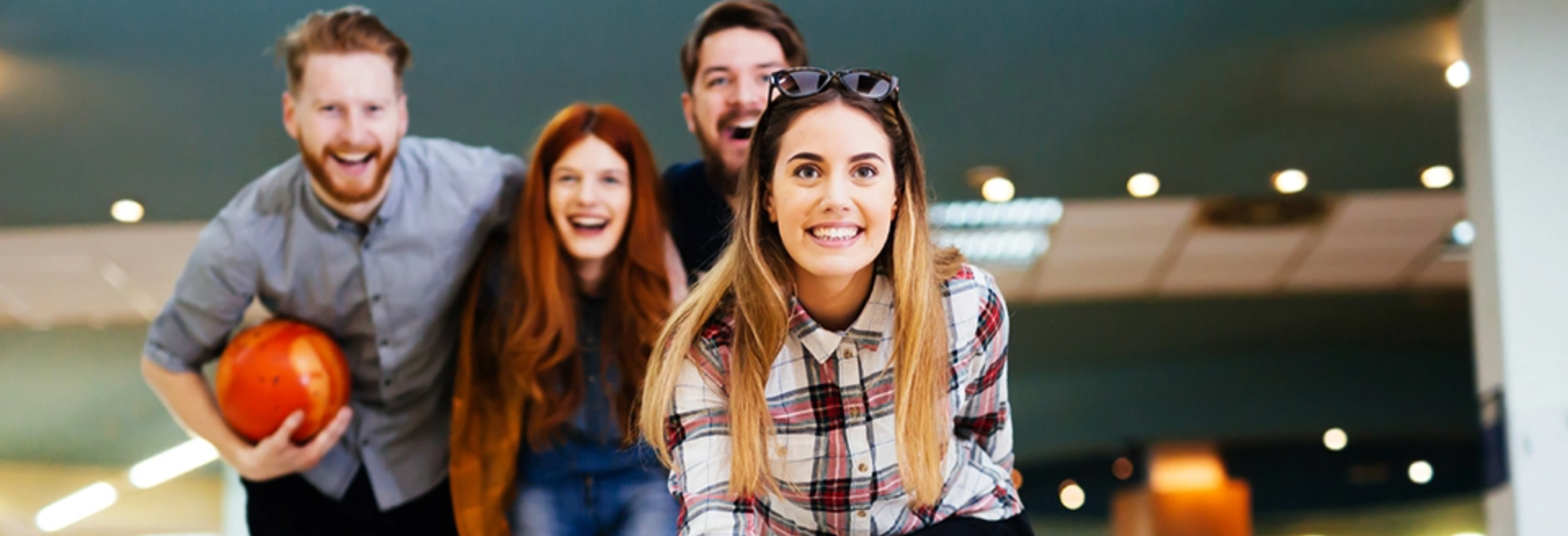 group of friends smiling and having fun whilst bowling 