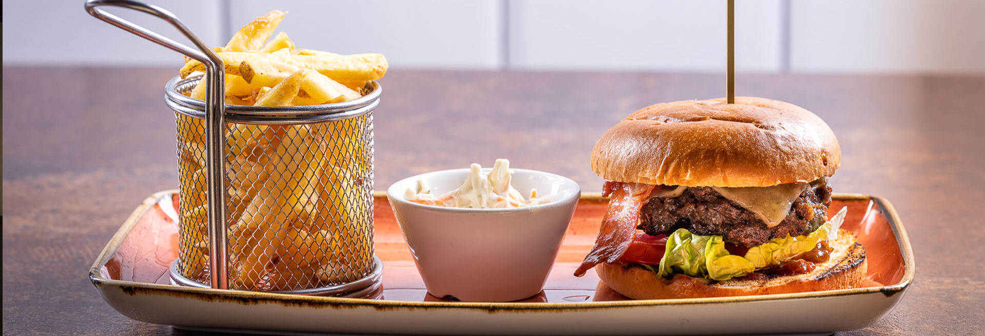 Beef burger with bacon and chips on a plate