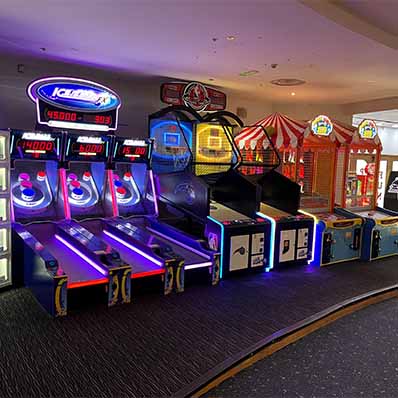 Dimly lit arcade room filled with arcade games