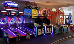 Dimly lit arcade room filled with arcade games