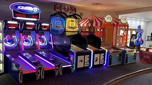 Dimly lit arcade room filled with arcade games